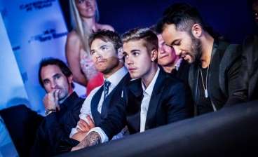  Canadian singer Justin Bieber takes his seat in the front row at the Amber Lounge event